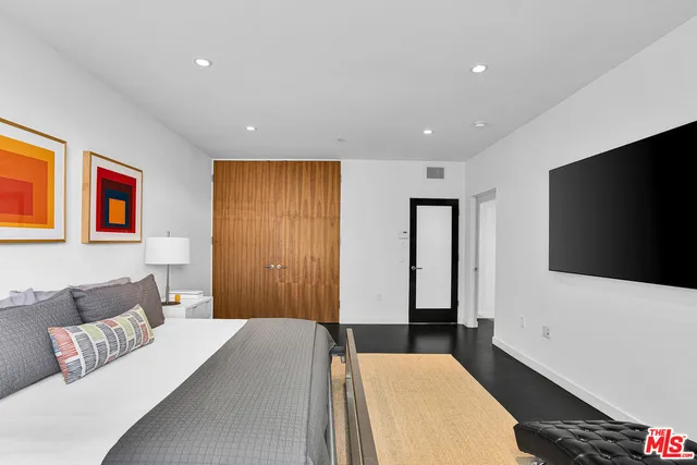 a bedroom with a bed and a flat screen tv