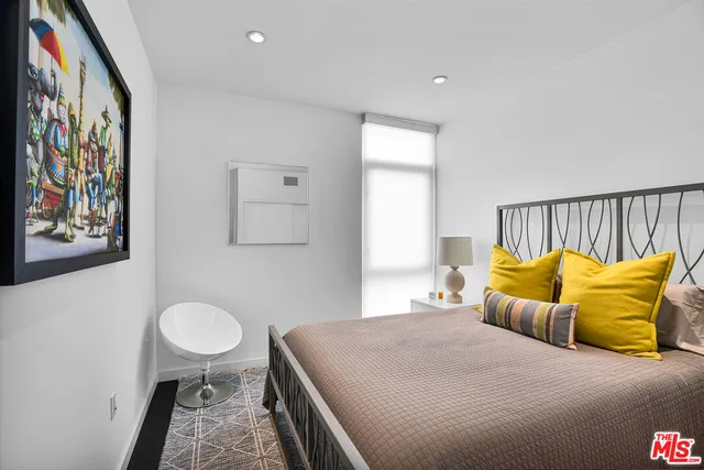 a bedroom with a bed and painting on the wall