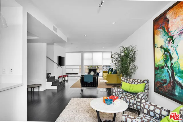 a living room with furniture and a floor to ceiling window