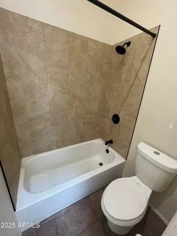a white toilet sitting next to a bath tub
