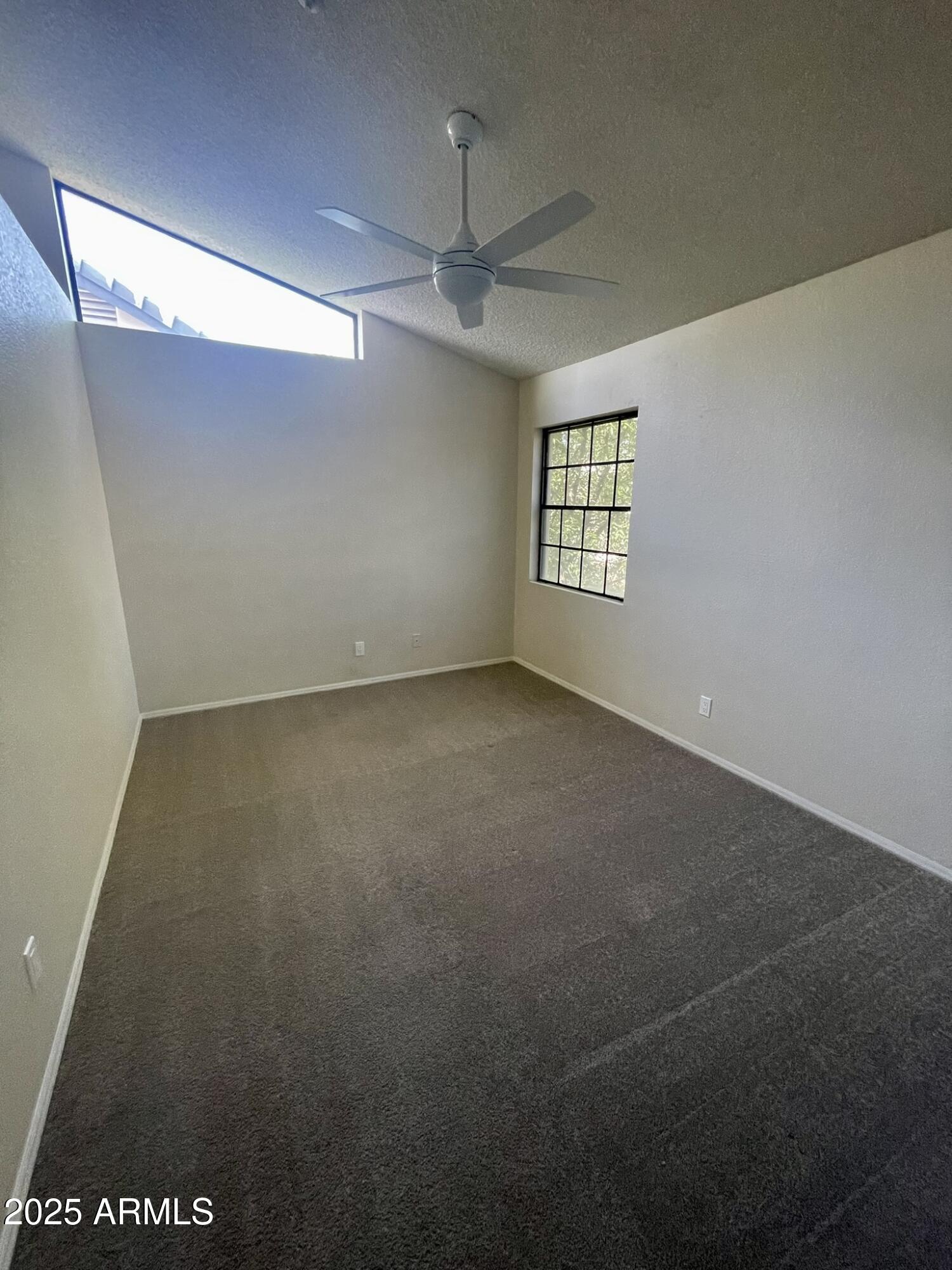 1124 East Rose Lane, Unit 3 Phoenix, AZ 85014 - Photo 17 of 32 an empty room with windows and ceiling fan