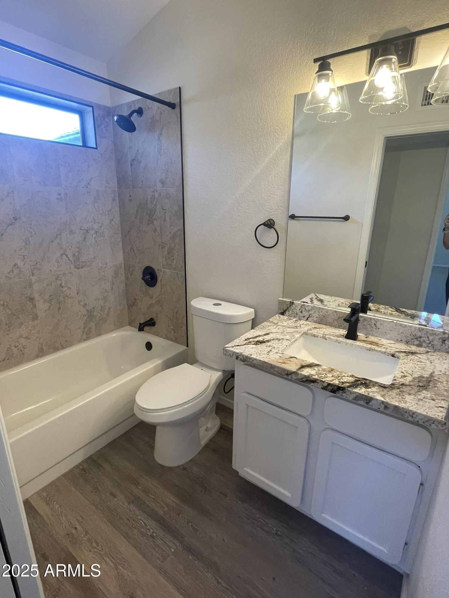 1124 East Rose Lane, Unit 3 Phoenix, AZ 85014 - Photo 18 of 32 a bathroom with a granite countertop sink toilet a mirror and bathtub