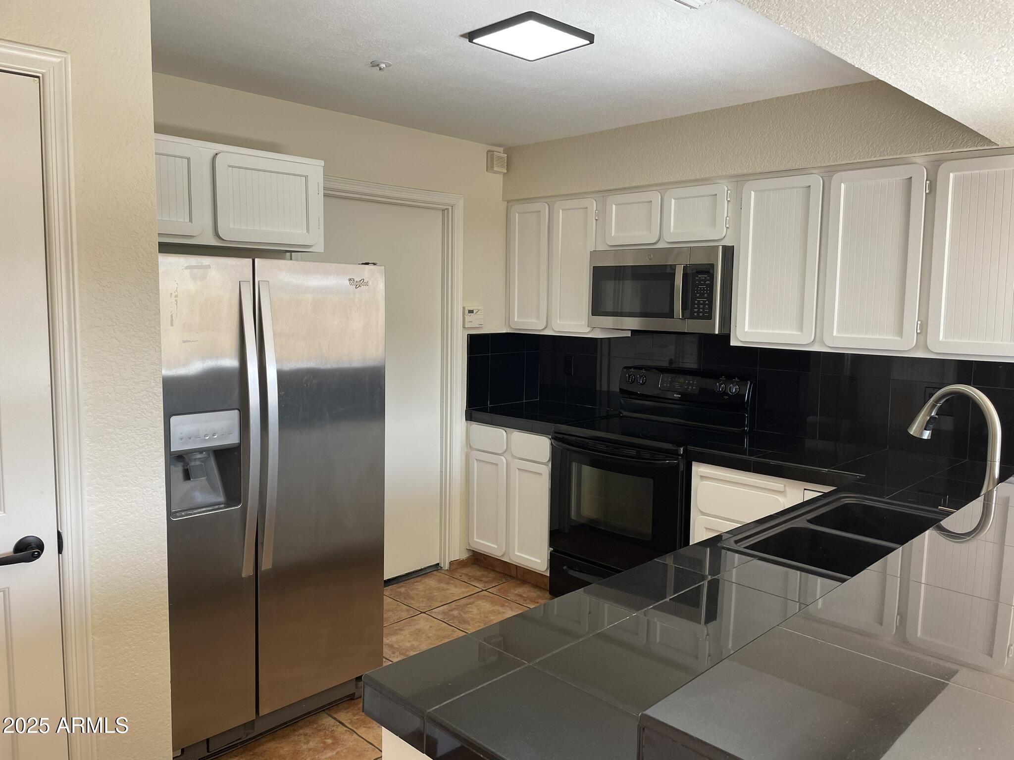 1124 East Rose Lane, Unit 3 Phoenix, AZ 85014 - Photo 5 of 32 a kitchen with a refrigerator stove and microwave