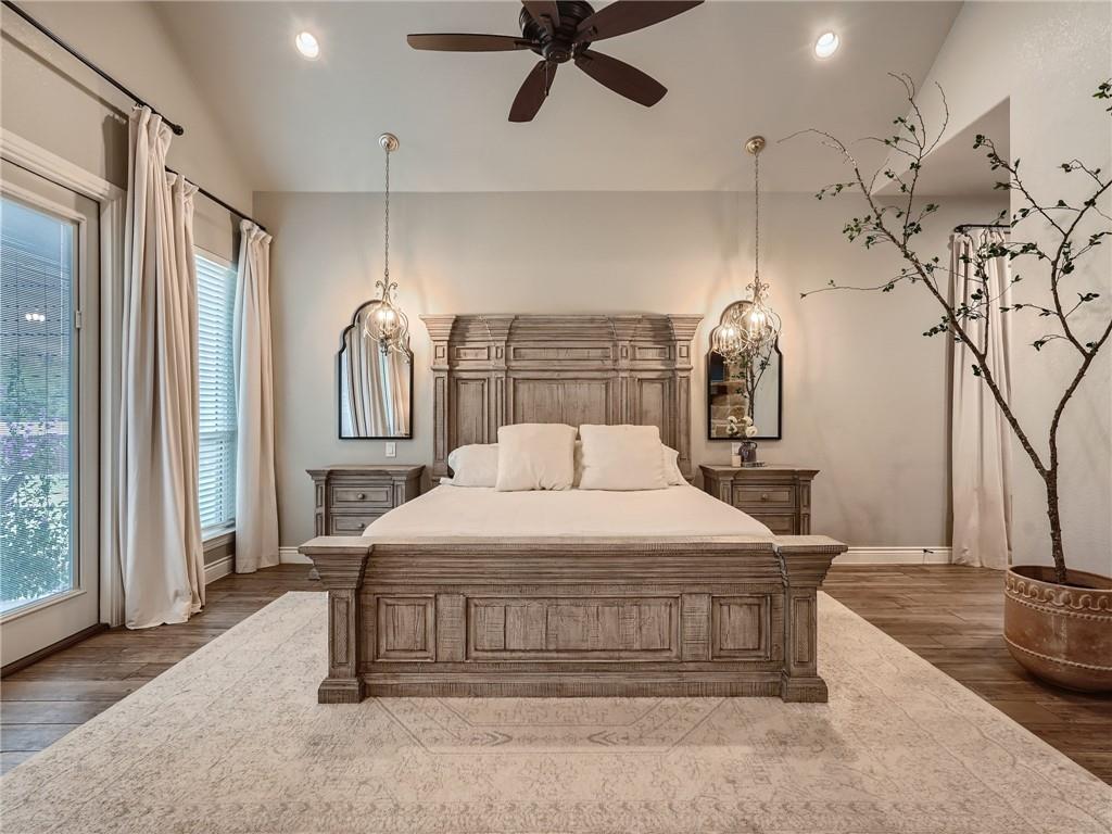 132 Huerta Road Florence, TX 76527 - Photo 14 of 40 Luxurious wooden bed frame anchors this naturally illuminated primary bedroom with elegant lighting and rich wood flooring.