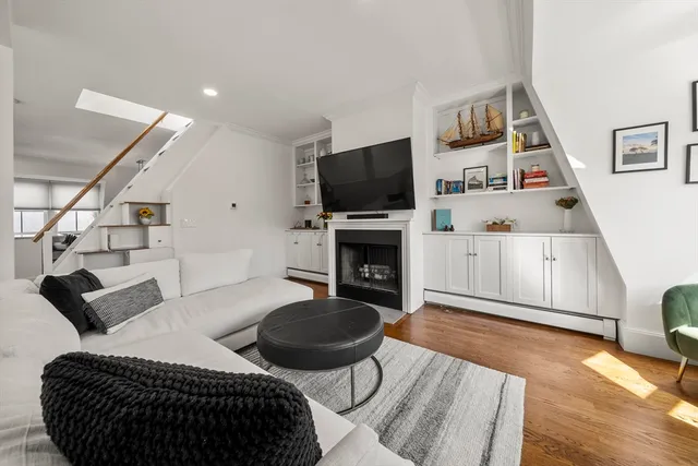 a living room with furniture a flat screen tv and kitchen view