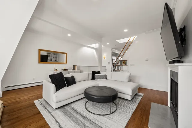 a living room with furniture a flat screen tv and a rug