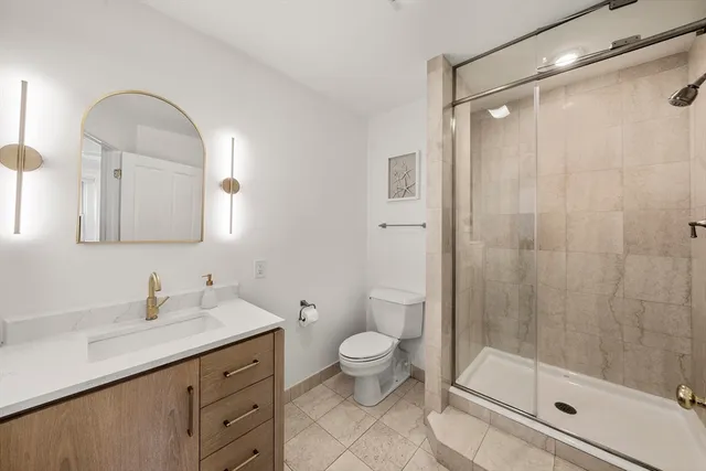 a bathroom with a double vanity sink toilet and shower