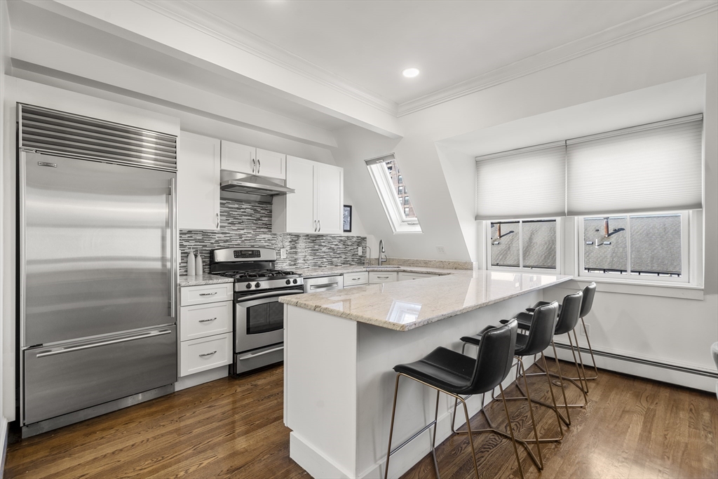 36 Upton Street, Unit 3 Boston, MA 02118 - Photo 4 of 33 a kitchen with kitchen island a stove a sink and a refrigerator