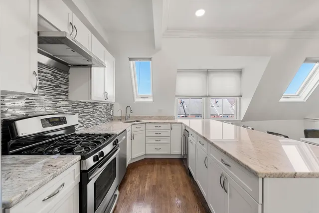 a kitchen with granite countertop a sink stove and cabinets