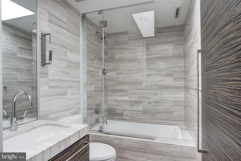 a large white bed sitting in a bathroom next to a window