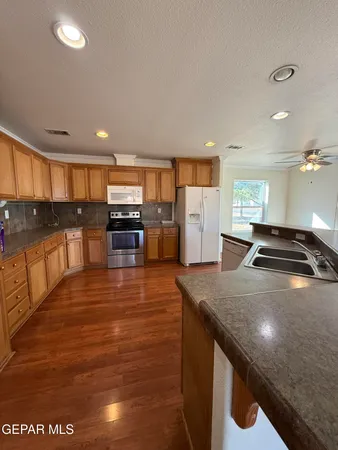 a kitchen with stainless steel appliances wooden cabinets a stove and a sink