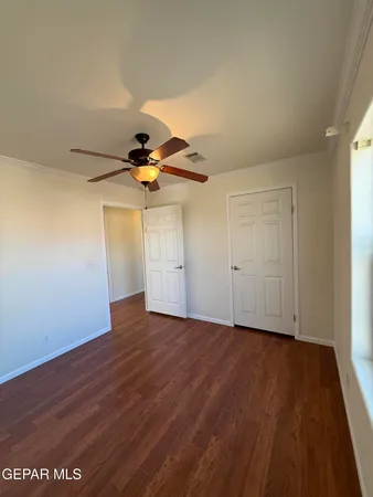 a view of empty room with wooden floor