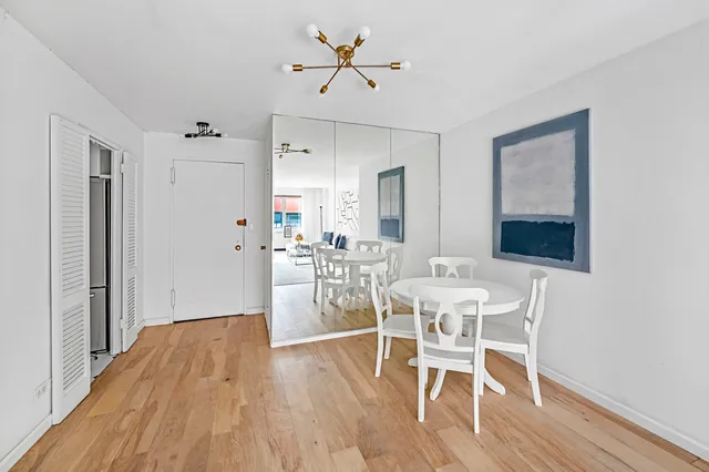 a dining room with furniture a chandelier and wooden floor