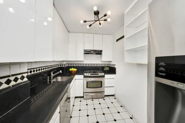 a kitchen with granite countertop a stove sink and cabinets