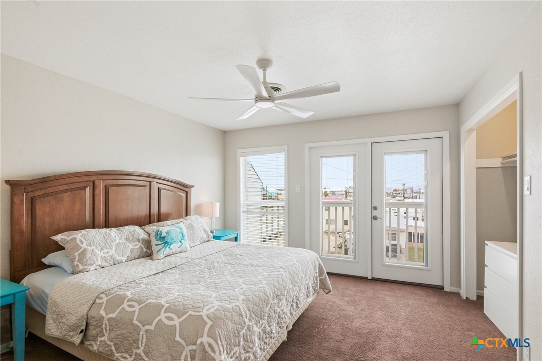 520 15th Street Port O'Connor, TX 77982 - Photo 31 of 36 a spacious bedroom with a large bed and a chandelier