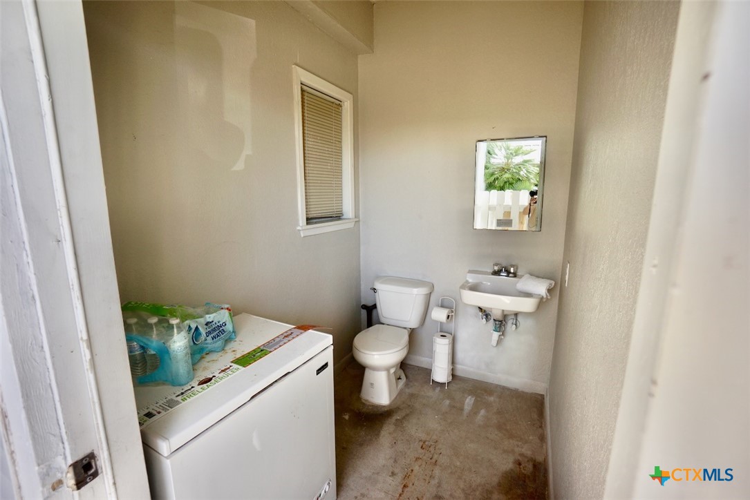 520 15th Street Port O'Connor, TX 77982 - Photo 7 of 36 a bathroom with a granite countertop toilet and a sink