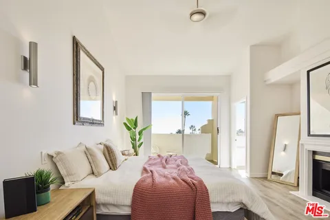 a bedroom with a bed and a potted plant