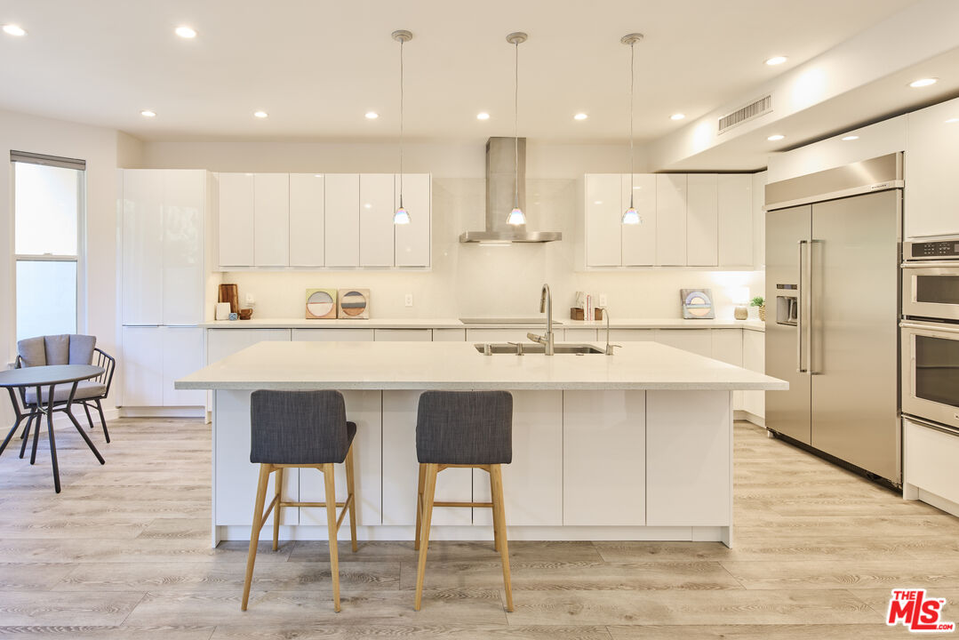 6465 Zuma View Place, Unit 163 Malibu, CA 90265 - Photo 8 of 26 a kitchen with stainless steel appliances kitchen island granite countertop a sink and a refrigerator