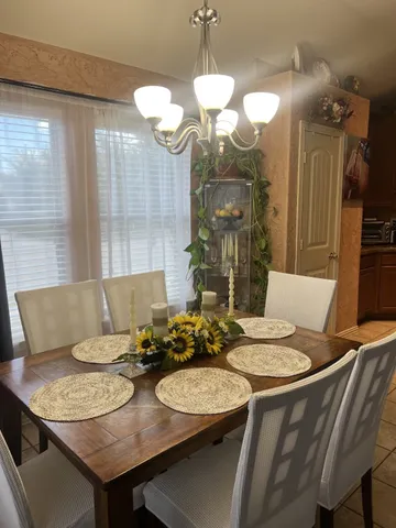 a view of a dining room with furniture and a chandelier