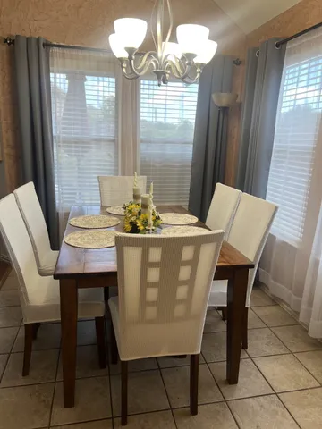 a dining room with furniture a chandelier and wooden floor