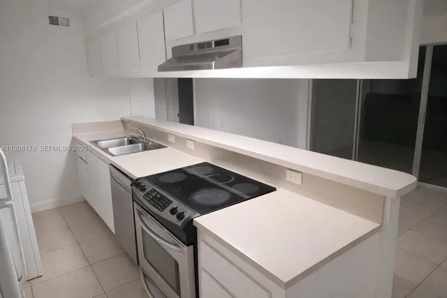 an empty room with windows and ceiling fan