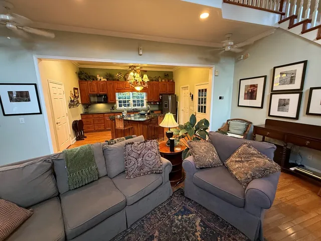 a living room with furniture a piano and a potted plant