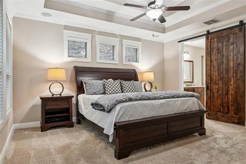 a spacious bedroom with a bed and a chandelier