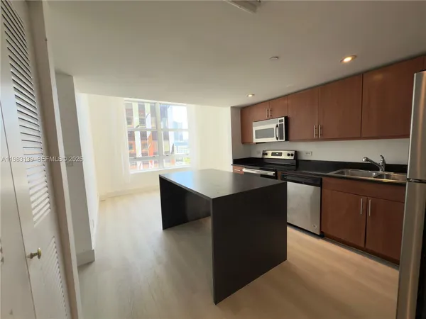 a kitchen with granite countertop a stove top oven a sink dishwasher and a microwave oven on the blue kitchen countertops