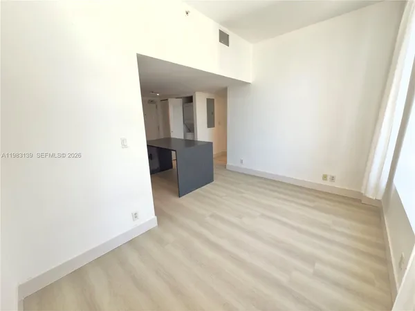 a view of a room with wooden floor and cabinet