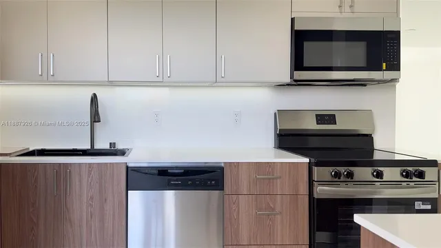 a kitchen with stainless steel appliances wooden cabinets and a stove top oven