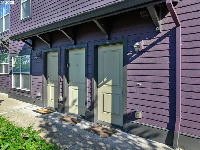 a view of a house with a door and wooden fence