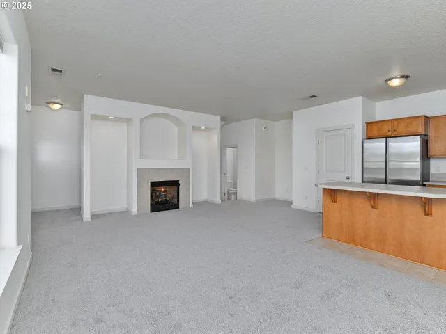 a view of an empty room with a fireplace and a window