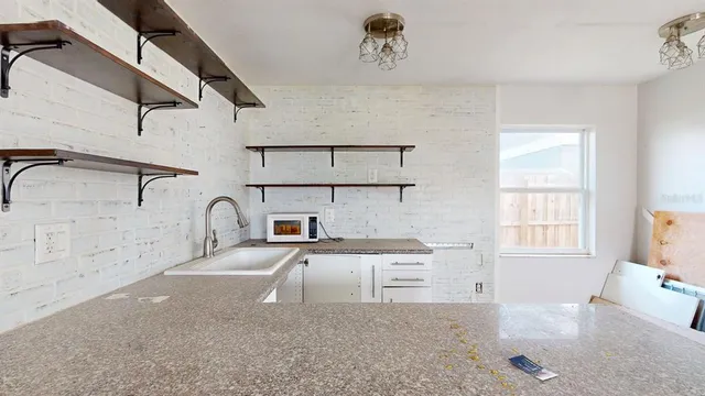 a kitchen with white cabinets and window