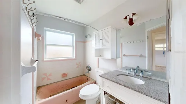 a view of an empty room and a chandelier fan