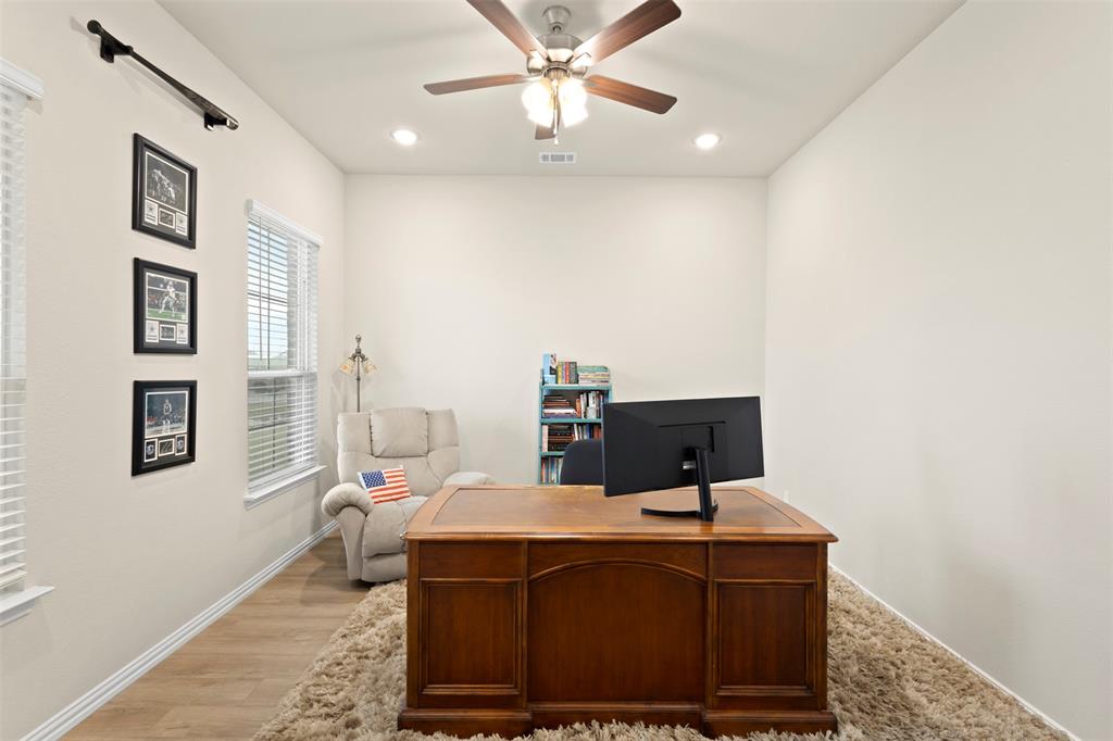 107 Yampa Court Rhome, TX 76078 - Photo 4 of 30 Versatile room featuring neutral wall tones, wood-finish flooring, two window openings with blinds, a ceiling fan with integrated lighting, and recessed ceiling lights