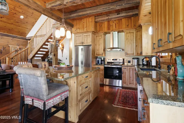 a kitchen with stainless steel appliances granite countertop a sink a stove and a wooden floors