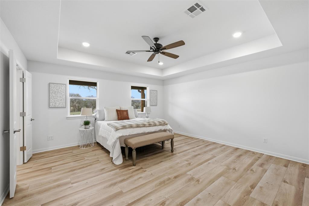 2303 Pilgrim Lane Lorena, TX 76655 - Photo 15 of 38 a spacious bedroom with a bed and a chandelier