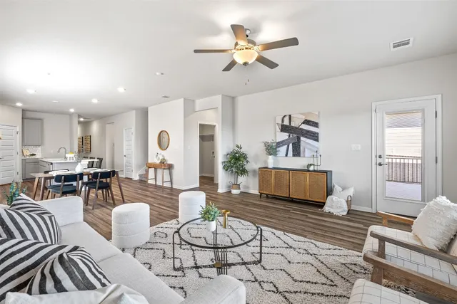 a living room with furniture a chandelier and a wooden floor