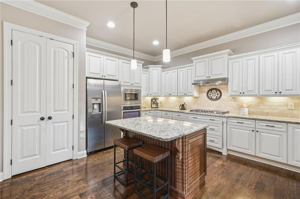 262 Trecastle Square Canton, GA 30114 - Photo 18 of 46 a kitchen with stainless steel appliances granite countertop a table chairs refrigerator and microwave