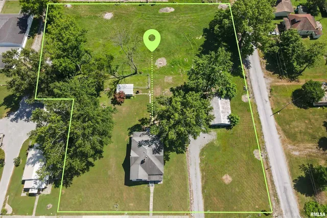 an aerial view of a residential houses with yard