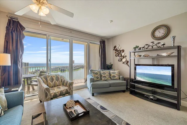 a living room with furniture a flat screen tv and a large window