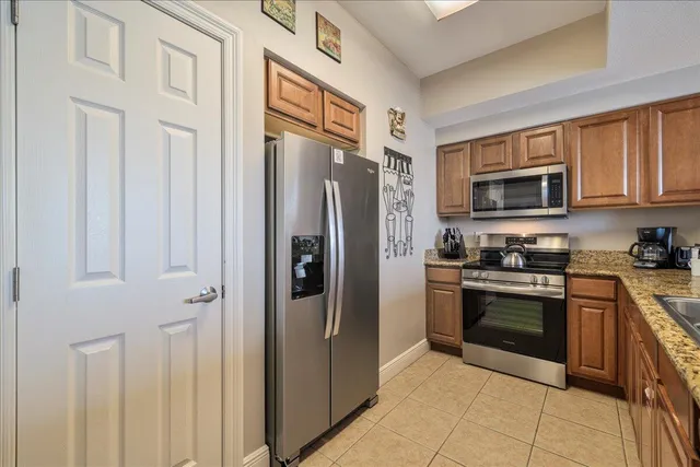 a kitchen with stainless steel appliances granite countertop a refrigerator oven a sink and dishwasher