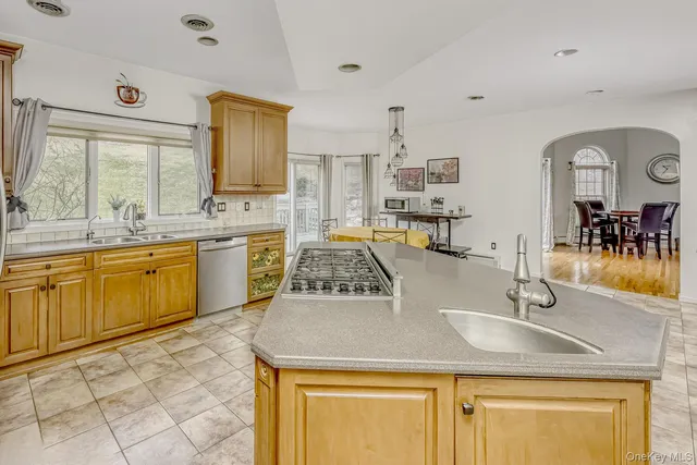 a view of a kitchen island a sink wooden floor and living room view