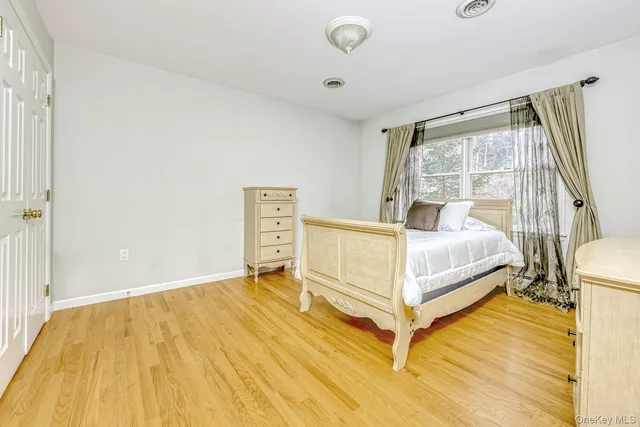 a bed sitting in a spacious bedroom next to a window