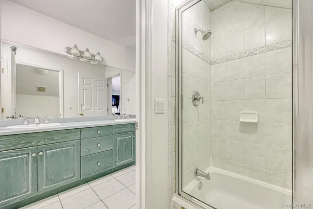 a bathroom with a double vanity sink mirror and shower