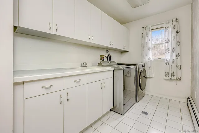 a utility room with cabinets washer and dryer