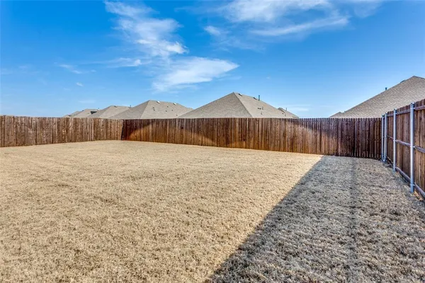 a view of a house with a yard and wooden fence