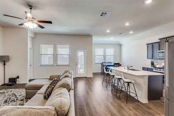 a living room with furniture and a wooden floor