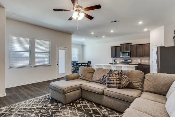 a living room with furniture kitchen view and a window