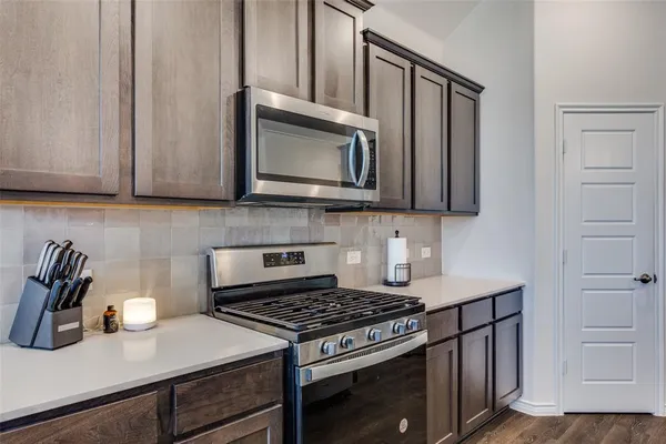 a kitchen with a counter space a sink cabinets and appliances